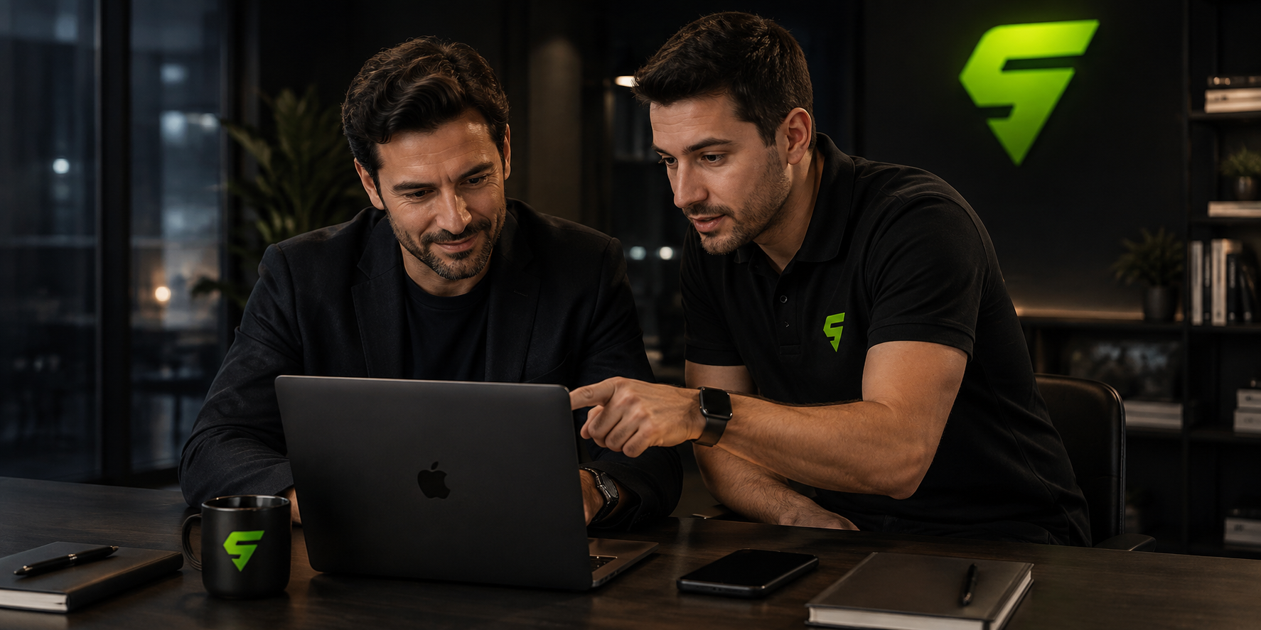 Consulente Squadd affianca un imprenditore davanti al laptop in ufficio, con il logo Squadd verde a parete: la parte tecnica fatta insieme, mese dopo mese.